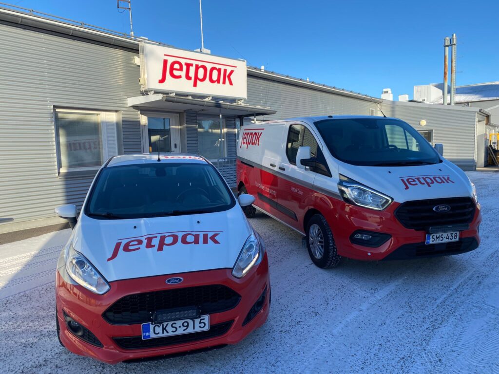 Jetpak Oulun pakettiauto ja henkilöauto parkkeerattuna Jetpak Oulun toimiston edessä